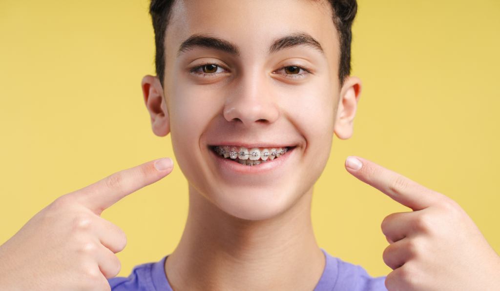 Kid wearing teeth braces, showing a bright smile with braces on their teeth.